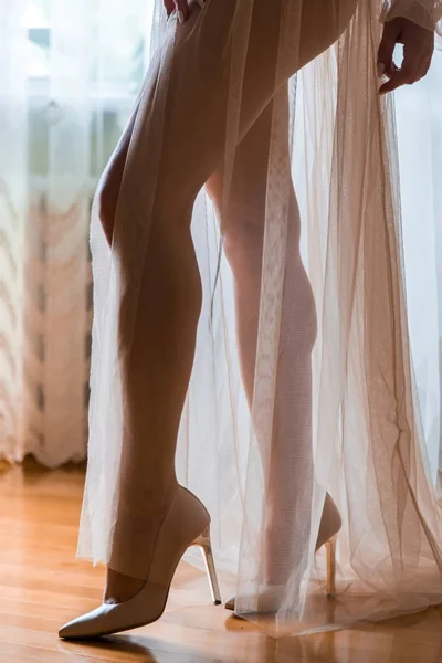 Die Beine der Bräute im Nachthemd im Gegenlicht. — Stockfoto