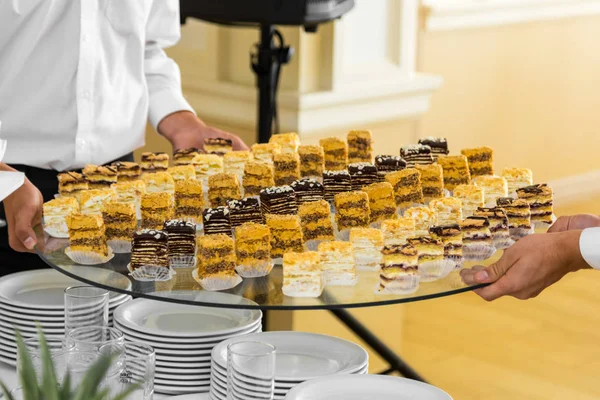 Kellner stellen ein süßes Gebäck auf den Buffettisch Stockfoto