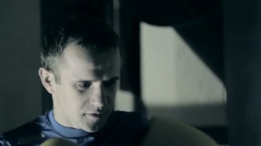 Mücadele öncesi atlet trenler. Bir boksör kum torbasına yumruk atıyor. Siyah arka plan