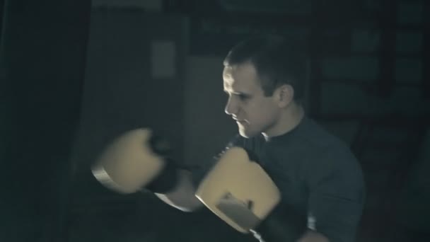 Atlet vlaky před bojem. Boxer rány boxovací pytel. Černé pozadí — Stock video