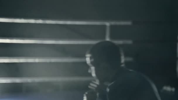 Boxeador en el ring entrena golpes rápidos. preparándose para la batalla. Fondo oscuro — Vídeo de stock