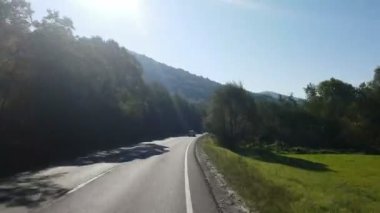 Pencere görünümünden Araba, otobüs, tren. Güneşli bir gün seyahat. Güzel dağlar sonbaharda seyahat