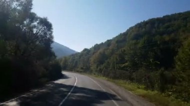 Pencere görünümünden Araba, otobüs, tren. Güneşli bir gün seyahat. Güzel dağlar sonbaharda seyahat
