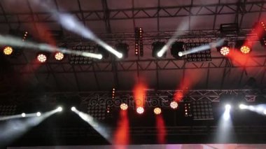 Büyük sahne aydınlatma. Farklı renklerde yanıp sönen ışıkları farklı yönlere hareket. Konserler, disko, gece kulüpleri, ışık.