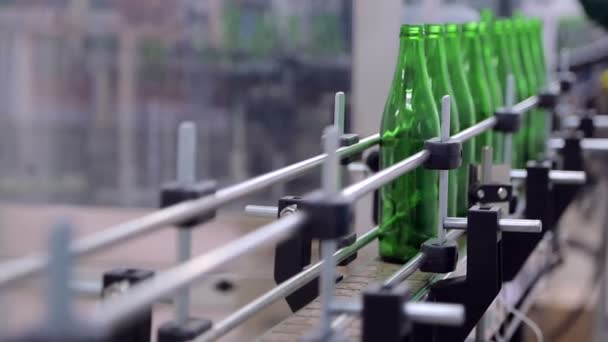 Linie der Wasserproduktion. Der Mitarbeiter stellt die Glasflaschen auf die Linie der automatischen Reinigung und Füllung mit Wasser. Panne auf der Linie. Flaschen fallen. Unregulierte Technik — Stockvideo