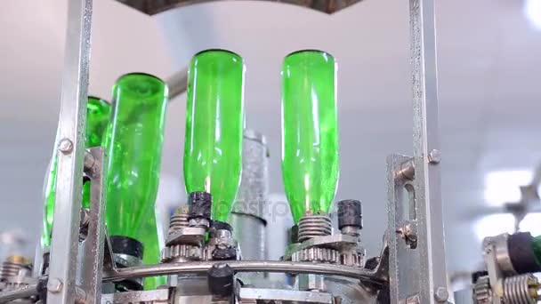 Лінія виробництва води. Зелені скляні пляшки рухаються вздовж лінії, вони автоматично промиваються перед наповненням водою — стокове відео