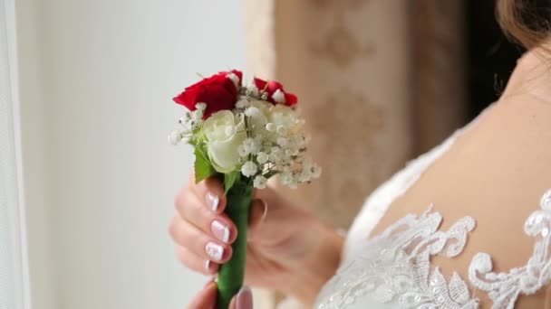 De bruid houdt de bloem in haar armen en draait haar — Stockvideo