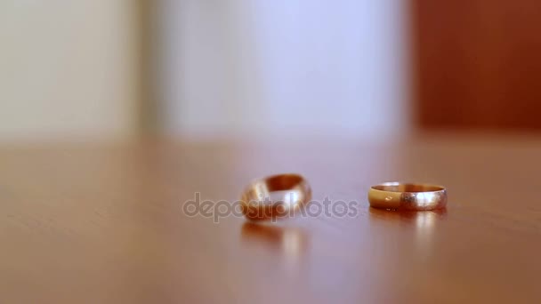 Um caso único. Dois anéis de casamento batem um no outro e caem um em um . — Vídeo de Stock
