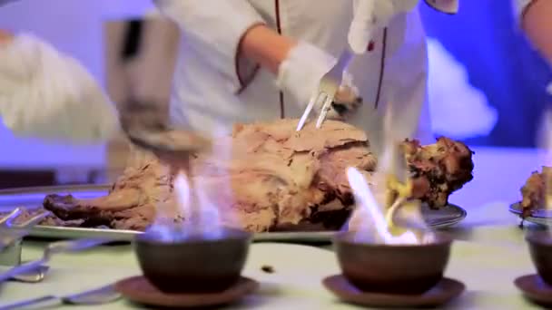 Il cameriere taglia la carne. Cattura una telecamera attraverso un fuoco — Video Stock
