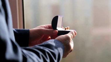 Damat nikah yüzükleri onun elinde kutusuyla tutar ve kapatır