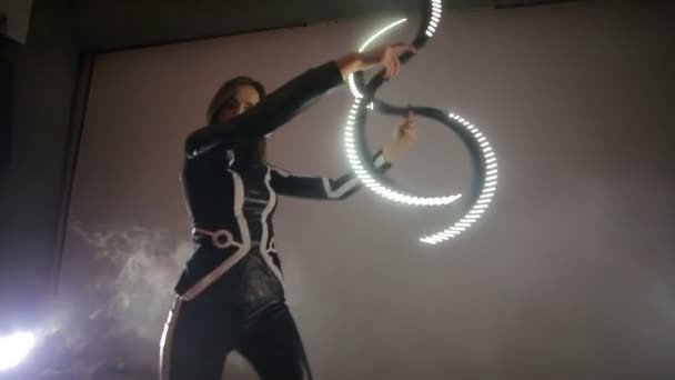 Spettacolo. Una donna tiene in mano un bastone piegato con del ghiaccio e lo fa girare abilmente. Movimento caotico e dinamico della fotocamera nel telaio . — Video Stock