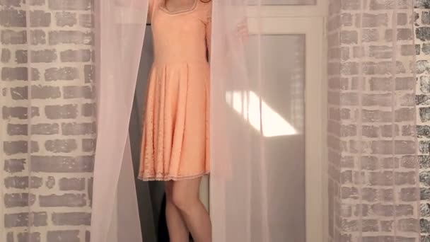 Flickan står på fönsterbrädan i oragami kjol. Flickan hänger sig åt en kjol — Stockvideo