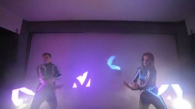 LED göstermek. Bir erkek ve bir kadın elinde bir arka ışık ile küçük bir sahnede Led hayranları twist.