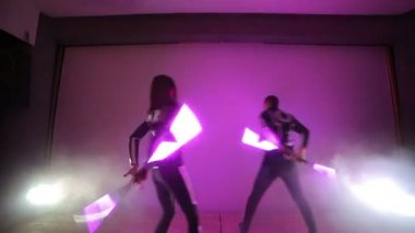 LED göstermek. Bir erkek ve bir kadın elinde bir arka ışık ile küçük bir sahnede Led hayranları twist.