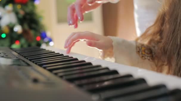 Mamá ayuda al niño a tocar el piano. Los dedos del primer plano hacen clic en las teclas del piano . — Vídeo de stock