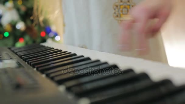 Mamá ayuda al niño a tocar el piano. Los dedos del primer plano hacen clic en las teclas del piano . — Vídeos de Stock