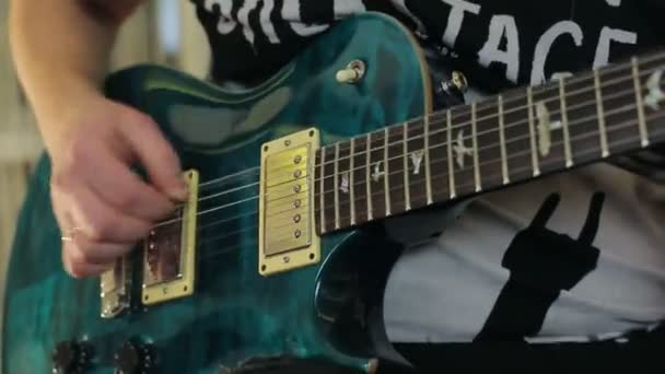 Ένας άντρας παίζει ένα πράσινο ηλεκτρική κιθάρα με ένα κοντινό πλάνο — Αρχείο Βίντεο