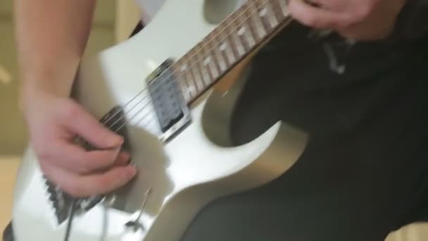 El hombre toca una guitarra blanca en un primer plano — Vídeos de Stock