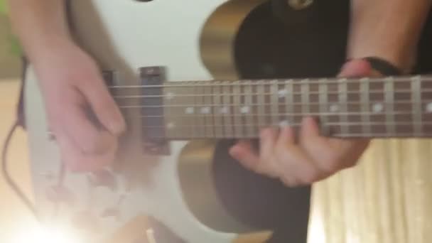Человек играет на белой гитаре на крупном плане — стоковое видео