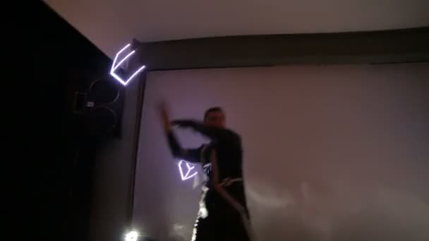 Espectáculo. Um homem e uma mulher em um pequeno palco com uma luz de fundo, nas mãos de fãs de LED de torção . — Vídeo de Stock