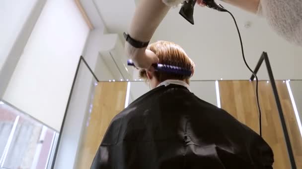 Mujer en un salón de belleza seca su cabello con un secador de pelo — Vídeos de Stock