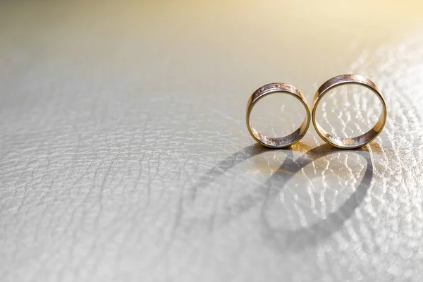 Arka ışık ile aydınlatılmış nişan yüzükleri gelen beyaz cilt üzerinde gölge düşer