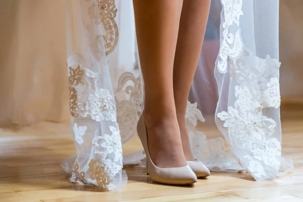 Seksualne nogi panny młodej. Panna Młoda stoi na drewnianą podłogę, buty w krem buty, a ona pokazuje jej piękne nogi — Zdjęcie stockowe