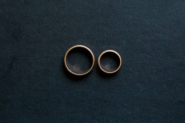 Snubní prsteny vypadají z výšky na černém pozadí Stock Fotografie