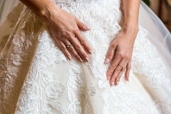 Szczelnie-do góry ręce narzeczonych delikatnie na tle sukni ślubnej — Zdjęcie stockowe