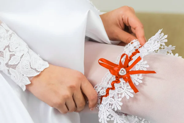 Bride wearing wedding garter. A woman demonstrates her sexy legs Stock Image