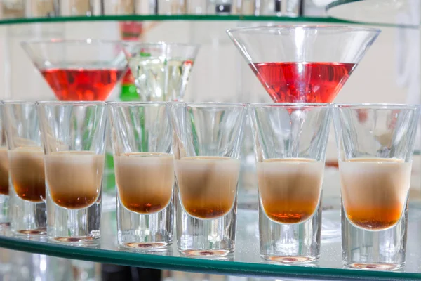 Cócteles alcohólicos en una superficie de vidrio, mesa de banquete . — Foto de Stock