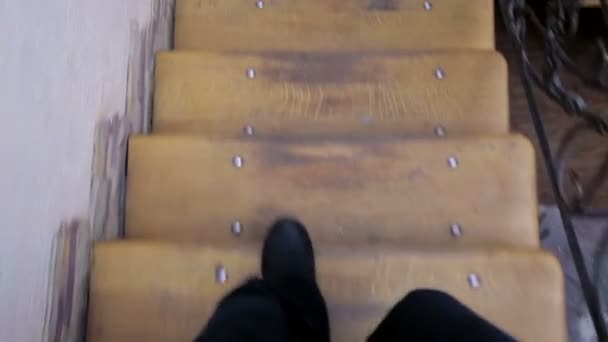 Disparando desde la primera persona. Las piernas de los hombres bajan las escaleras de madera — Vídeo de stock