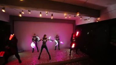 LED göstermek. Bir takım konfeti ile kaplı bir sahnede 5 sanatçıların ustaca juggles Led parlaklık sopa ile