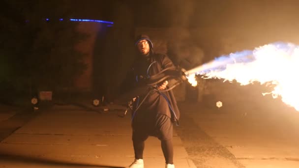 Kunstenaar met een vlammenwerper in zijn hand tijdens een optreden. Vuurshow. — Stockvideo