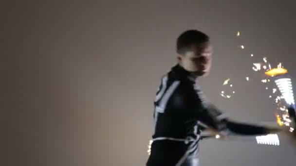 LED Toon. Man op een klein podium met een backlight, in de handen van twist Led fans. — Stockvideo