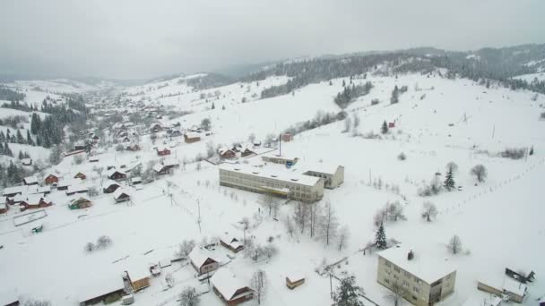 Полет над городом в горах. Зимний заснеженный город в Украинских Карпатах — стоковое видео