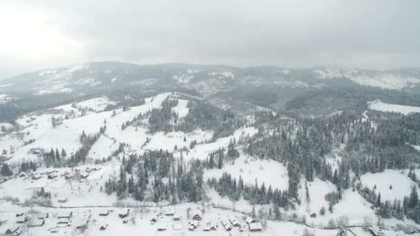 Volo sopra la città in montagna. Inverno città innevata nei Carpazi ucraini — Video Stock