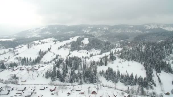 Volo sopra la città in montagna. Inverno città innevata nei Carpazi ucraini — Video Stock