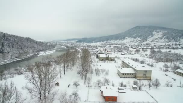 Luchtfoto vliegen boven de rivier in de winter. rivier kronkelen door adembenemende besneeuwde winterlandschap. — Stockvideo