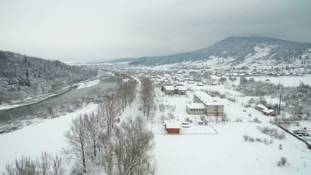 Luchtfoto vliegen boven de rivier in de winter. rivier kronkelen door adembenemende besneeuwde winterlandschap. — Stockvideo