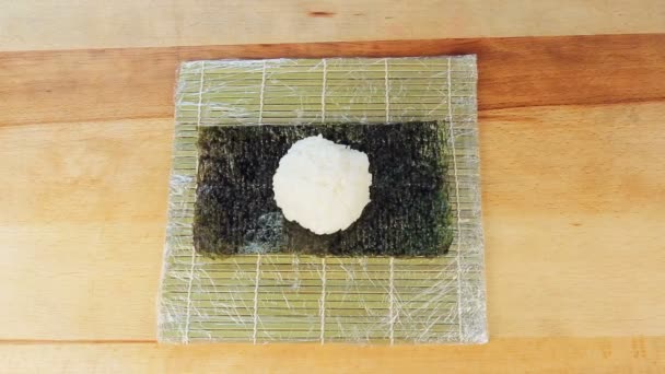 Koki menyiapkan sushi dengan menempatkan beras di alga Nuri — Stok Video