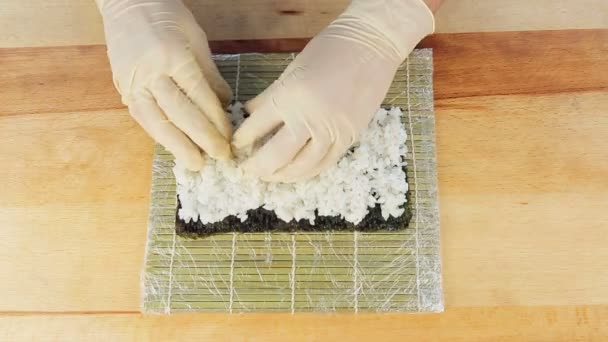 El chef prepara sushi colocando arroz en las algas Nuri — Vídeos de Stock