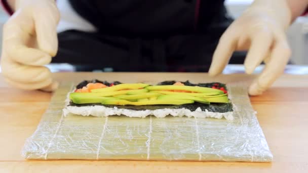 El chef se pone aguacate en sushi — Vídeo de stock