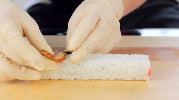 Майстер готує суші з використанням бамбукового килимка і норі морських водоростей — стокове відео