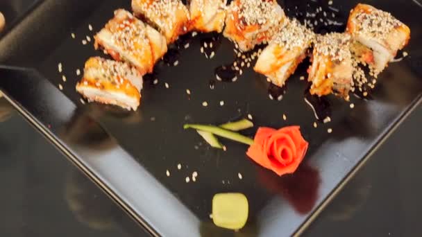 Sushi na czarnej płycie udekorowane różami w Ginger — Wideo stockowe