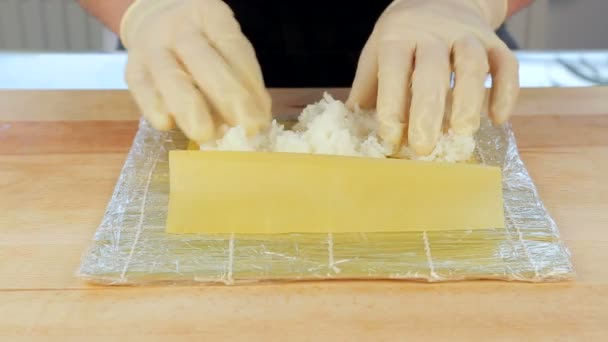 El chef prepara sushi colocando arroz en las algas Nuri — Vídeo de stock