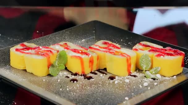 Sushi en un plato negro decorado con rosas en jengibre — Vídeos de Stock