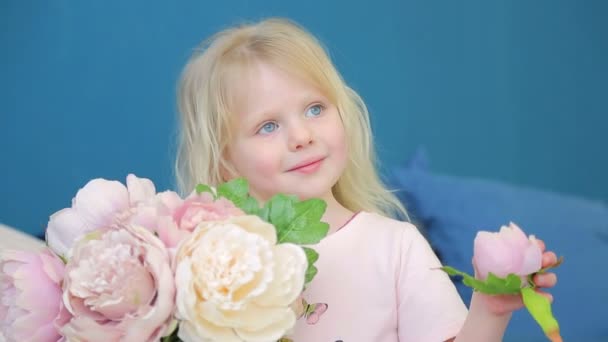 Dziewczynka gospodarstwa Duży wazon z kwiatami i odtwarza je w swoim pokoju na łóżku — Wideo stockowe
