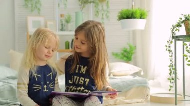 Bitkiler, parlak bir odada iki küçük kız kitap okumak