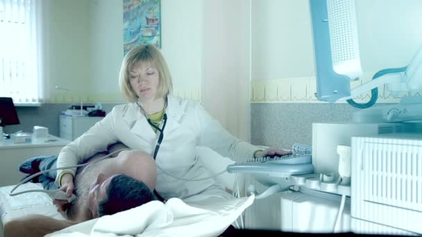 El médico examina a un paciente con ultrasonido. Diagnósticos y ecografía del paciente — Vídeo de stock